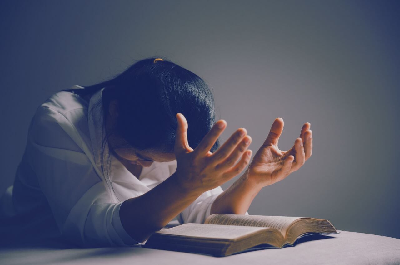 woman praying and reading the bible